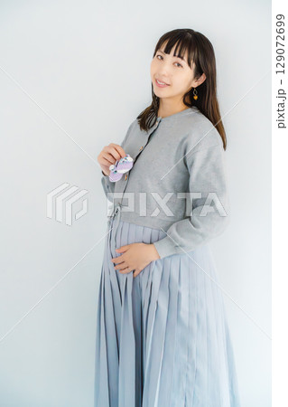 手編みのベビーシューズを持つ出産間近の妊婦 129072699