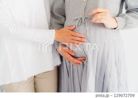 しあわせ一杯の母と臨月間近の娘 しあわせ一杯の母と臨月間近の娘 129072709