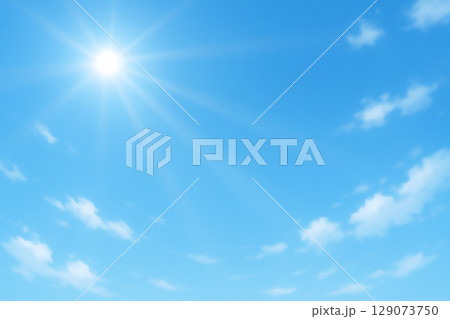 太陽の光が広がる濃い青空の背景、光筋が差し込む快晴の空模様、放射状に輝く太陽と明るい空 129073750