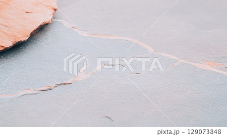 Rustic stone surface with cracks and texture showcasing natural beauty and detail in an outdoor setting 129073848