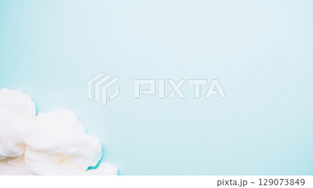 Soft white flowers arranged elegantly on a pale blue background creating a serene and peaceful atmosphere 129073849