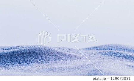 Soft white sand dunes under a clear sky during daylight hours creating a serene coastal landscape 129073851