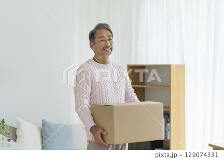 ダンボール箱を持ったシニア男性　引越し・断捨離　イメージ　 129074331
