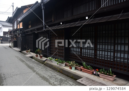 日本の岐阜県の春　高山市中心部の古い町並み　歴史的な日本家屋と道端に置かれた美しい鉢植え 129074584
