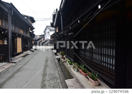 日本の岐阜県の春　高山市中心部の古い町並み　歴史的な日本家屋と道端に置かれた美しい鉢植え 129074586