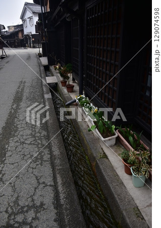 日本の岐阜県の春　高山市中心部の古い町並み　歴史的な日本家屋と道端に置かれた美しい鉢植え 129074598