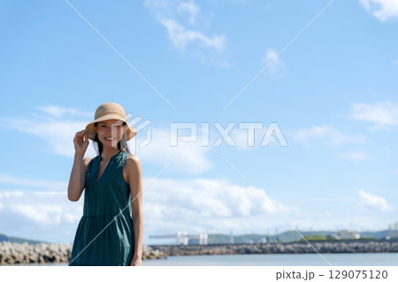 青い海に立つ若い女性 129075120