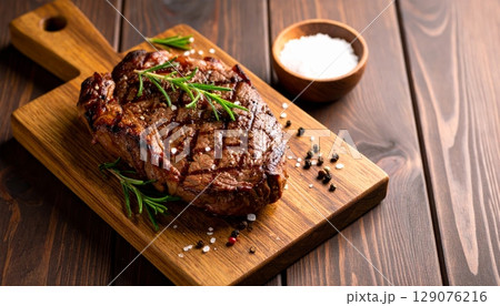 Savory raw pork chops with spices on a wooden board for a gourmet dinner Savory raw pork chops with spices on a wooden board for a gourmet dinner 129076216