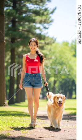 公園で犬の散歩をする女性 129076701