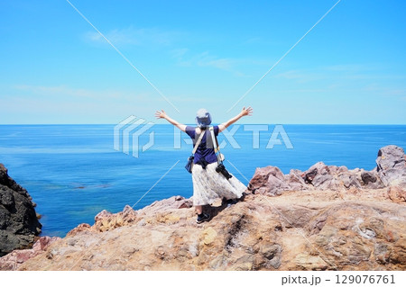 青い海を前に両手を広げる女性 青い海を前に両手を広げる女性 129076761