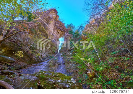 秋の群馬県下仁田町の県立妙義公園のハイキングコースの第二石門を内側(つるべさがり)から見る 秋の群馬県下仁田町の県立妙義公園のハイキングコースの第二石門を内側(つるべさがり)から見る 129076784