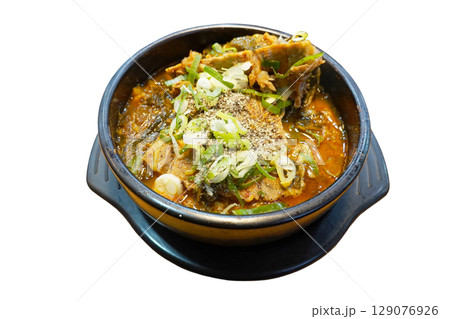 Hearty spicy Korean pork bone soup with vegetables and green onions served in traditional black stone pot perfect comfort food 129076926