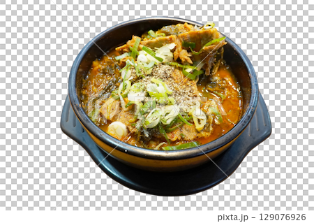 Hearty spicy Korean pork bone soup with vegetables and green onions served in traditional black stone pot perfect comfort food 129076926