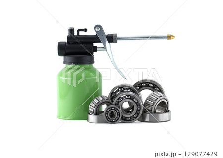 Detailed shot of various bearings with a green oil can, isolated on white. Detailed shot of various bearings with a green oil can, isolated on white. 129077429
