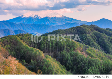 春の山々と雲に包まれた富士山 129078219