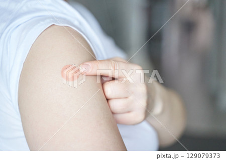 Caucasian female adult showing arm vaccination patch after injection Caucasian female adult showing arm vaccination patch after injection 129079373