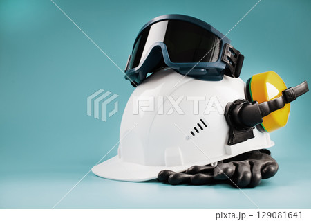 Yellow headphones with a white helmet and dark welding glasses on a blue background 129081641
