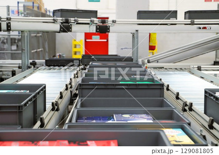 packing line in a logistics warehouse. conveyor belt in a modern production line packing line in a logistics warehouse. conveyor belt in a modern production line 129081805