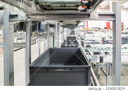 packing line in a logistics warehouse. conveyor belt in a modern production line packing line in a logistics warehouse. conveyor belt in a modern production line 129081824
