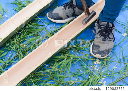 流しそうめん用の竹を金槌で加工する作業の様子 129082753