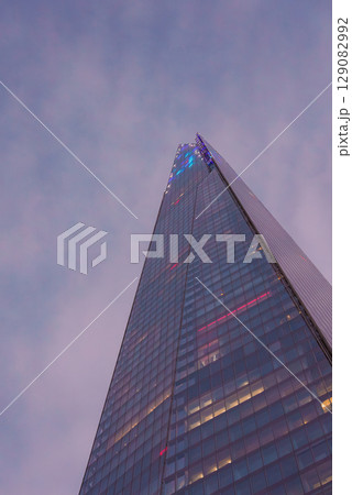 The Shard in London is captured from a low angle, highlighting its height and modern design. Subtle lighting and a dusky sky enhance the glass facade. The Shard in London is captured from a low angle, highlighting its height and modern design. Subtle lighting and a dusky sky enhance the glass facade. 129082992