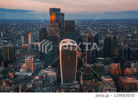 The London skyline features the Walkie Talkie and Cheesegrater buildings at sunset. Modern architecture contrasts with historic structures during Christmas. The London skyline features the Walkie Talkie and Cheesegrater buildings at sunset. Modern architecture contrasts with historic structures during Christmas. 129083030
