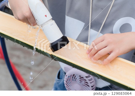流しそうめん用の竹に水を流す様子 129083064