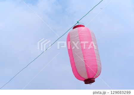 青空に映えるピンク色の提灯　夏祭りの風物詩 129083299