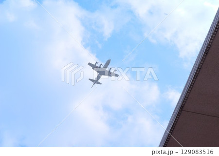 青空を飛ぶ自衛隊の哨戒機 都市上空を通過するP-3Cオライオン 青空を飛ぶ自衛隊の哨戒機 都市上空を通過するP-3Cオライオン 129083516