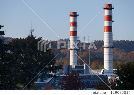 Two striped red and white factory pipes stand side by side 129083834
