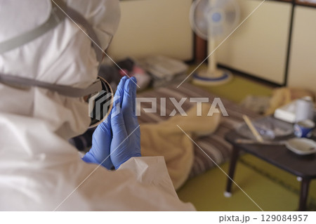 ゴミ屋敷清掃現場の防護服作業員 129084957