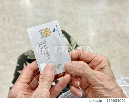 クレジットカードを持つ高齢者の両手の指_右空間 129085092
