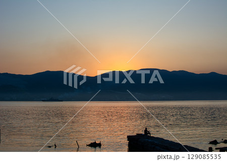 Golden sunrise over mountainous coastline 129085535