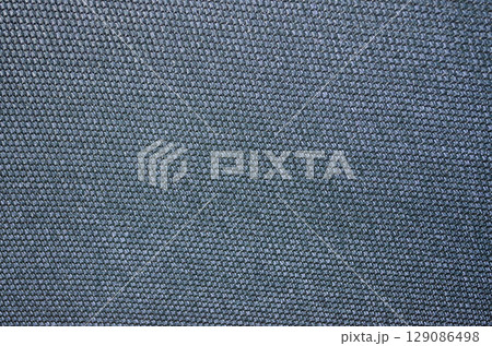 Close-up of a blue-green woven fabric with a textured surface 129086498