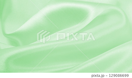 Smooth elegant green silk or satin luxury cloth texture as abstract background. Luxurious background design Smooth elegant green silk or satin luxury cloth texture as abstract background. Luxurious background design 129086699