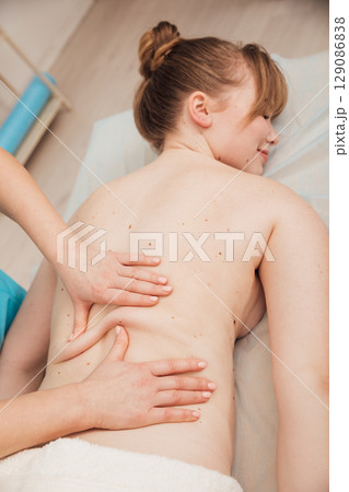 Masseur doing hands medical back massage to woman 129086838