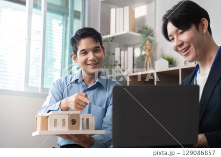 Architectural Collaboration. Professionals discussing building model and design concepts. Architectural Collaboration. Professionals discussing building model and design concepts. 129086857