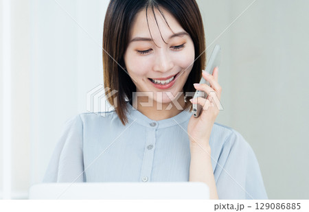スマホとパソコンを使う女性 129086885