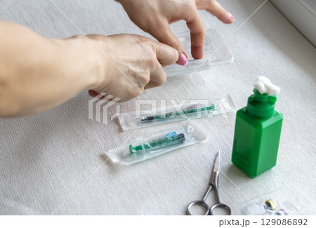 Close upshot of the woman preparing medicine for injection. 129086892