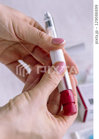 Close upshot of the woman preparing medicine for injection. Close upshot of the woman preparing medicine for injection. 129086899