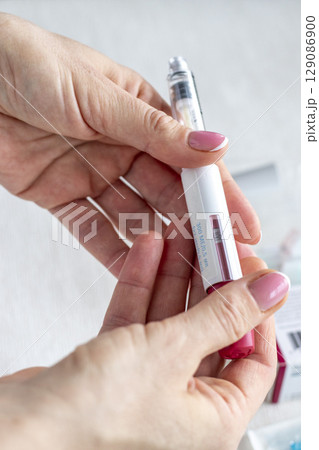 Close upshot of the woman preparing medicine for injection. 129086900