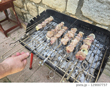 Outdoor summer barbecue with grilled meat skewers and charcoal grill party setup Outdoor summer barbecue with grilled meat skewers and charcoal grill party setup 129087737