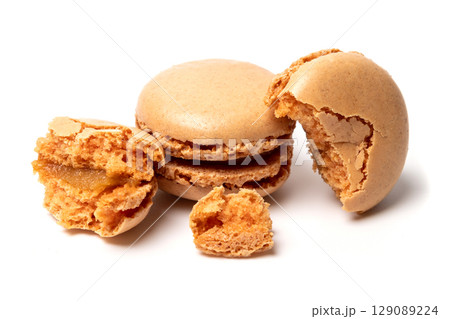 Broken into pieces tasty sweet original classic macaroon cake isolated on white studio background 129089224