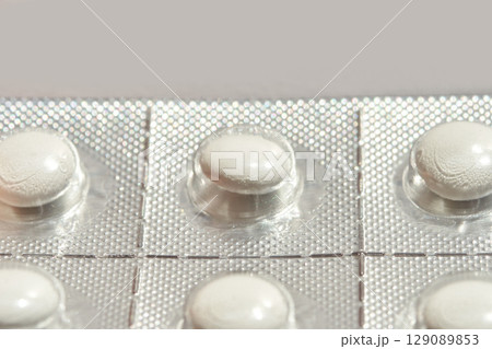 Blister pack with white pills in silver foil packaging for medicine Blister pack with white pills in silver foil packaging for medicine 129089853