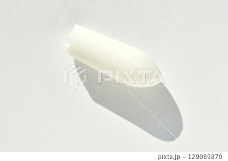 White suppository with shadow on light background highlighting its shape 129089870