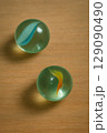 Two Glass Marbles on Wooden Surface Two Glass Marbles on Wooden Surface 129090490