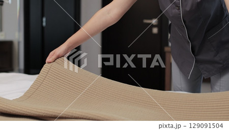Woman housekeeper preparing bed clothes in the hotel room. Cleaning service in hotel rooms, hotel business. Woman housekeeper preparing bed clothes in the hotel room. Cleaning service in hotel rooms, hotel business. 129091504