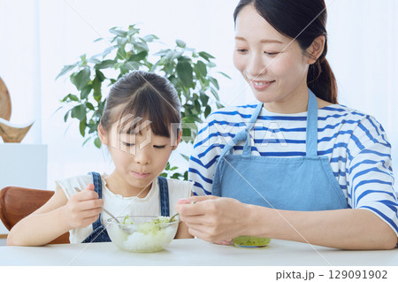 かき氷を食べる娘とやさしく見守る母親の夏のひととき 129091902