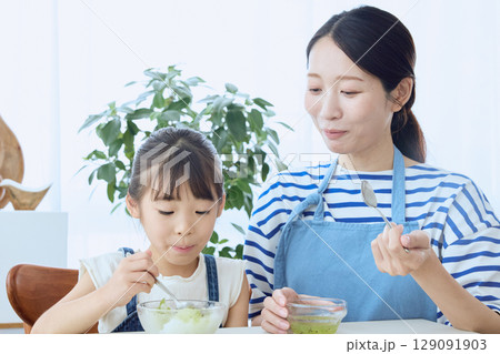 かき氷を食べる娘とやさしく見守る母親の夏のひととき 129091903