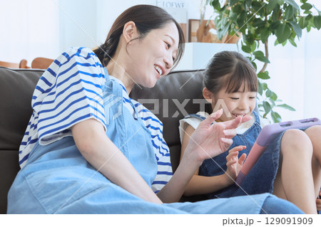 ソファで笑い合う母と娘の幸せなひととき 129091909